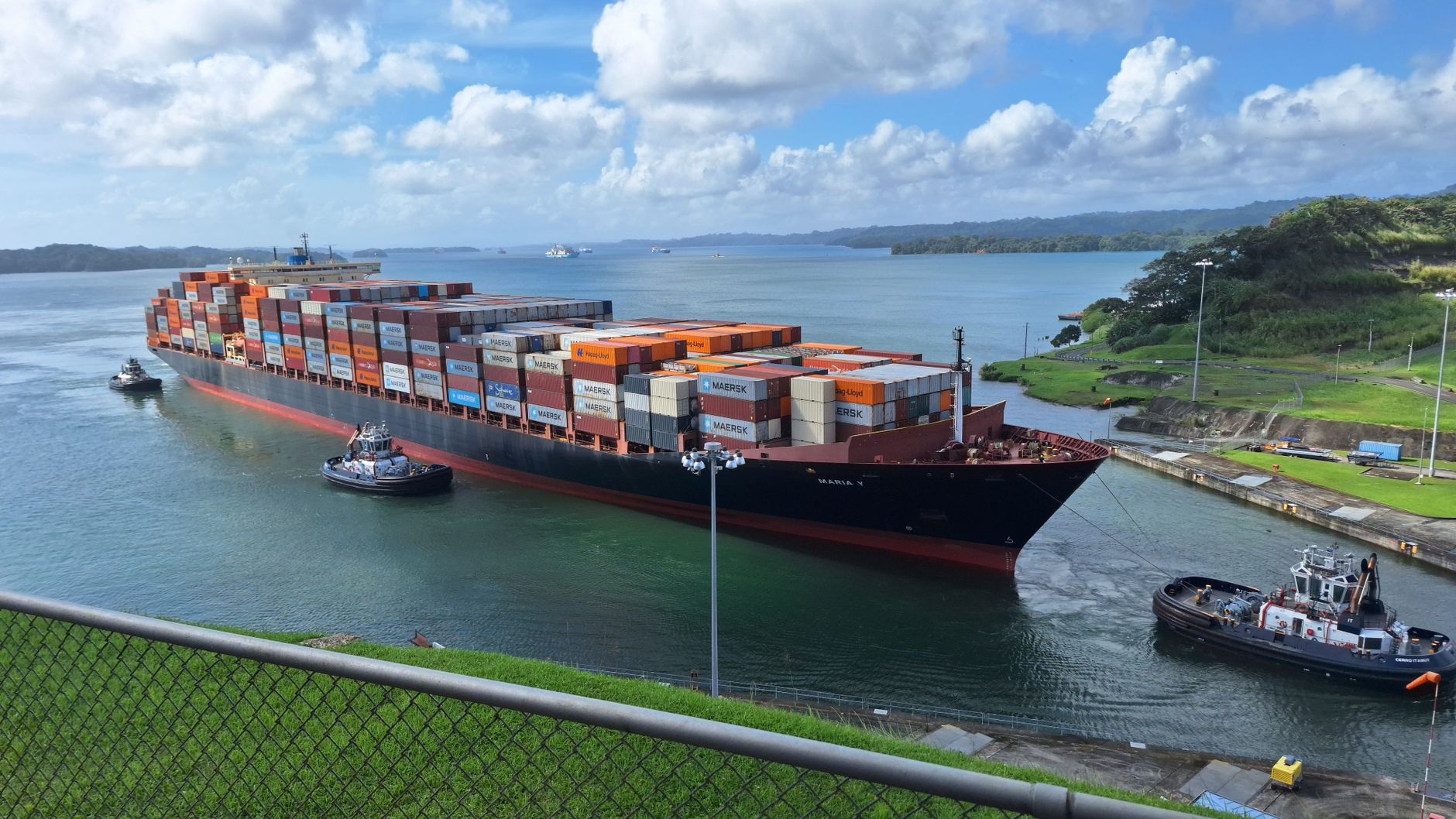 Container ship assisted by tugboats
